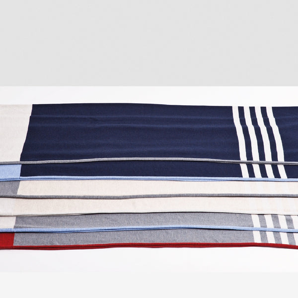 Assortiment à plat de couvertures en laine de mérinos avec rayures blanches / Merino wool blankets with white stripes made in Canada by Volprivé.