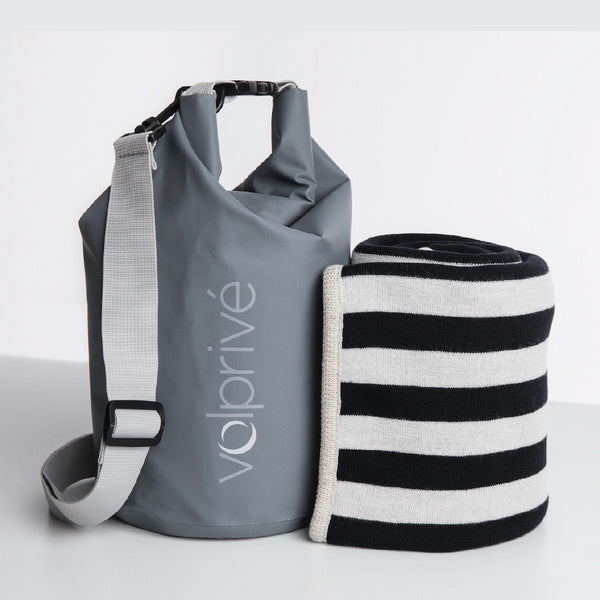 Couverture noire avec rayures grises et sac de voyage gris Volprivé / Black with stripes travel blanket with grey travel bag by Volprivé.
