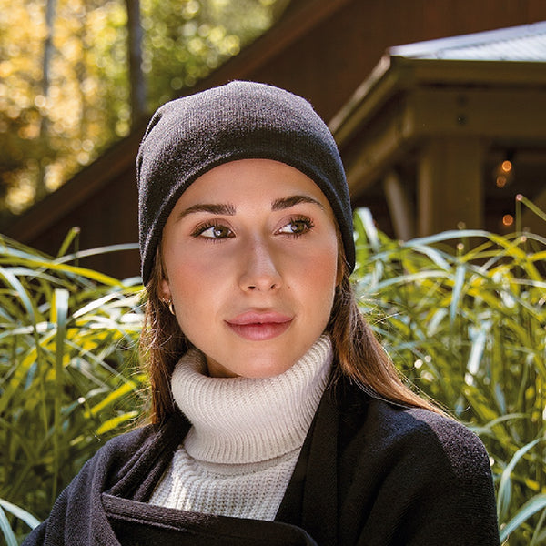 Tuque noire 100% mérinos sur jeune femme fabriquée au Canada / Black beanie on women model made of 100% merino wool by Volprivé.