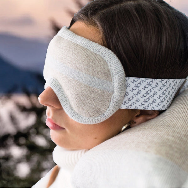 Jeune femme portant masque de sommeil lesté beige dans décor lac et forêt / Young women wearing a beige weighted sleep mask made by Volprivé.