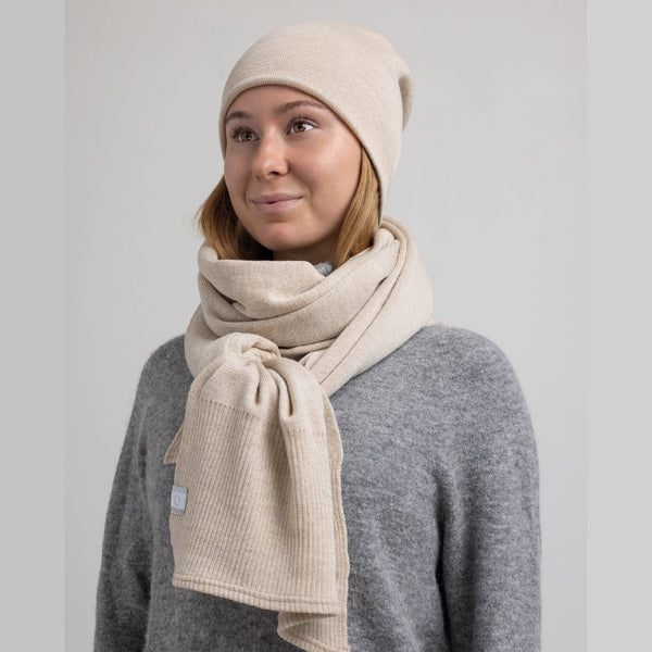 Jeune femme portant set foulard et tuque beige en laine de mérinos / Young women set of toque and scarf in merino wool beige by Volprivé.