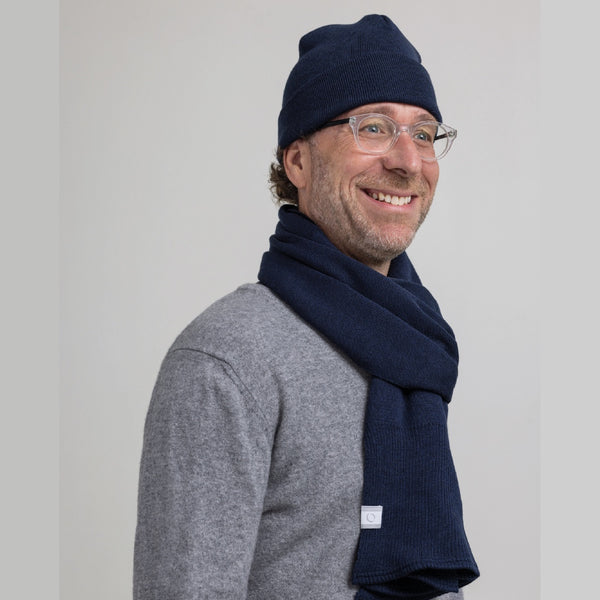 Homme portant set foulard et tuque bleu marine en laine de mérinos / Man set of toque and scarf in merino wool navy blue by Volprivé.