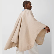 Vue de dos jeune femme portant châle en laine mérinos beige / Back view of young women wearing a beige merino wool shawl made in Canada by Volprivé.
