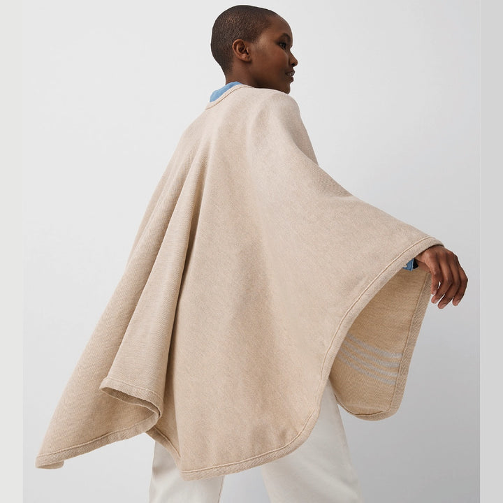 Vue de dos jeune femme portant châle en laine mérinos beige / Back view of young women wearing a beige merino wool shawl made in Canada by Volprivé.